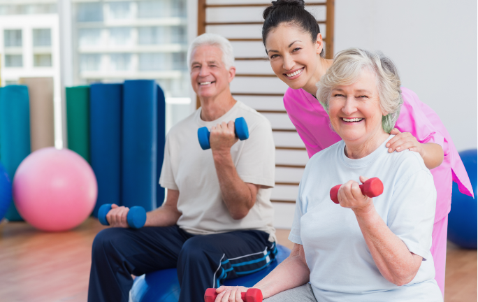 Therapist encouraging an elderly woman to perform arm stretching exercises