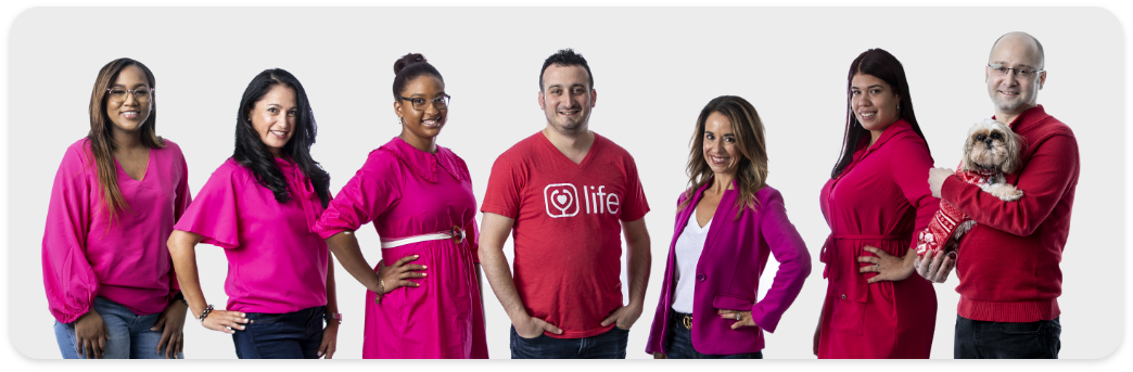 Group of medical professionals sitting in a row smiling at the camera.